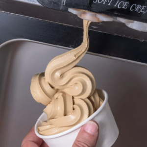 Chocolate soft serve dispenses into cup